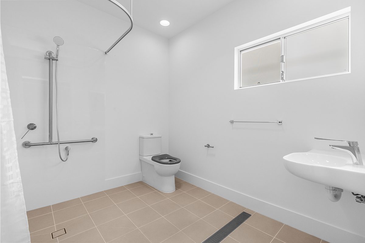 Accessible bathroom with level entry shower, grab rails and a fold down seat