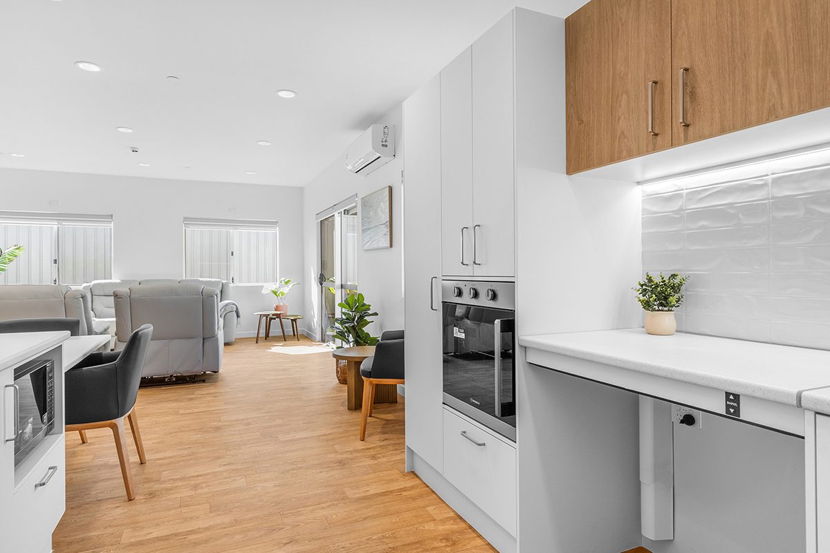 Kitchen with a height adjustable bench and clear space beneath for a wheelchair