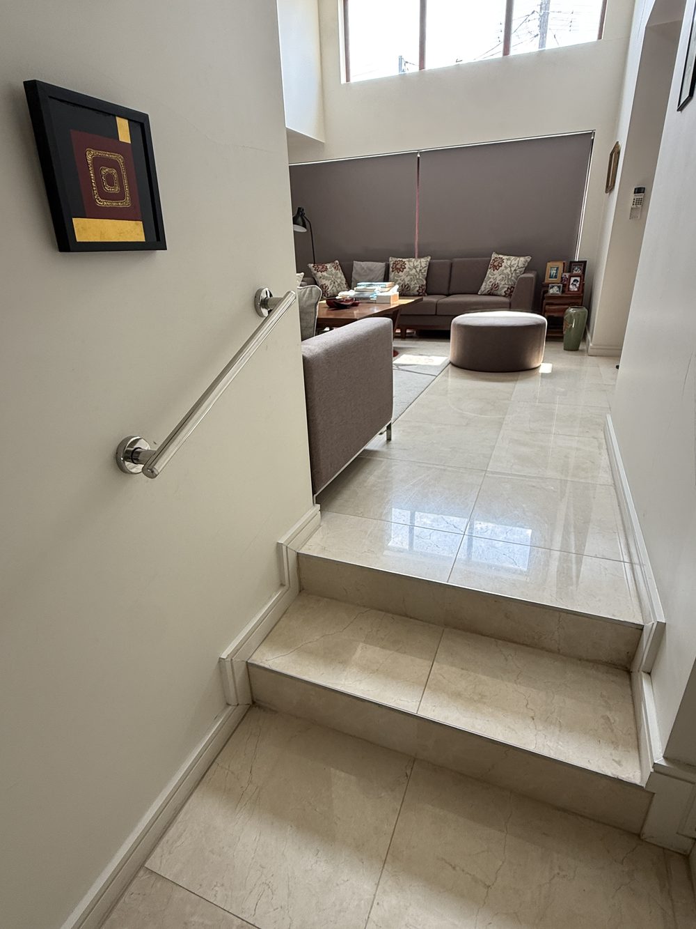 Handrail fitted beside internal steps leading up into a living room